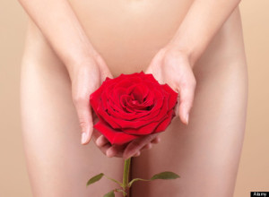 Nude woman holding a red rose in front of her naked body. Womens health concept.